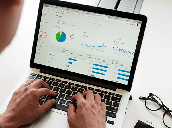 A person viewing a graph on a laptop